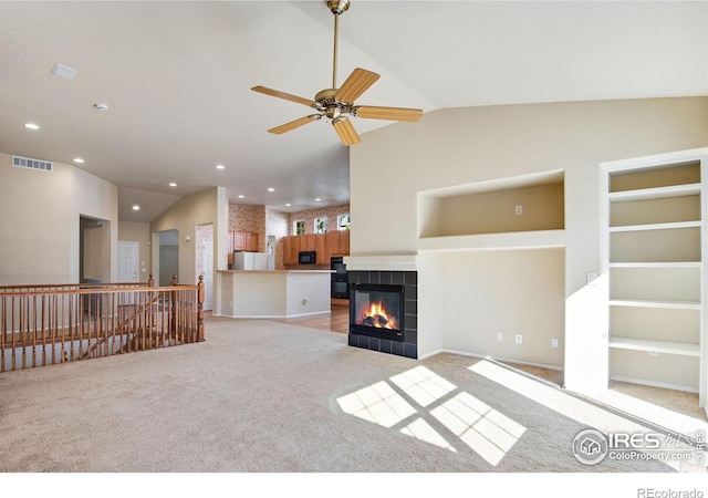 unfurnished living room featuring light carpet, visible vents, vaulted ceiling, and a tile fireplace