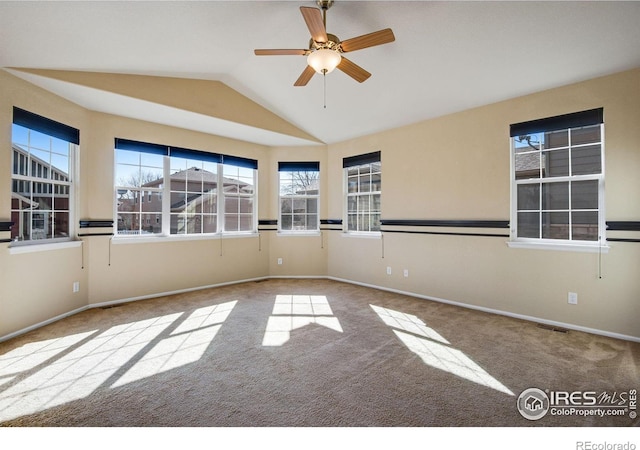 carpeted empty room featuring visible vents, vaulted ceiling, baseboards, and ceiling fan