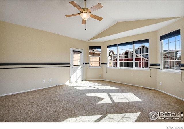 empty room with lofted ceiling, carpet, baseboards, and ceiling fan