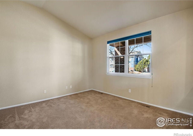 unfurnished room featuring lofted ceiling, baseboards, visible vents, and carpet flooring