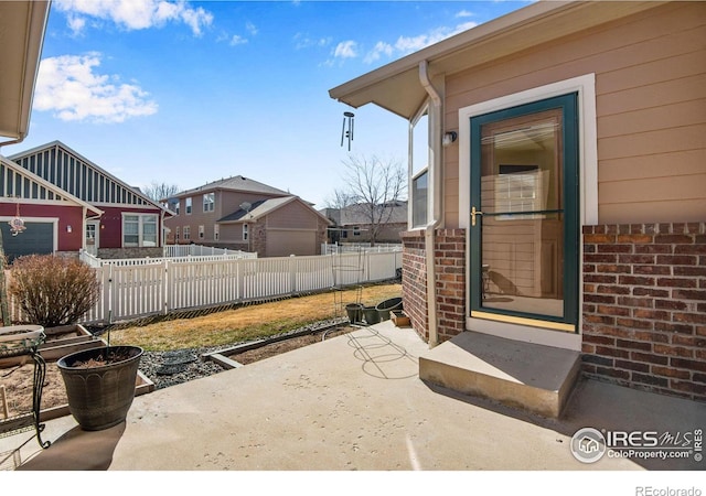 view of patio with a residential view, fence, and entry steps