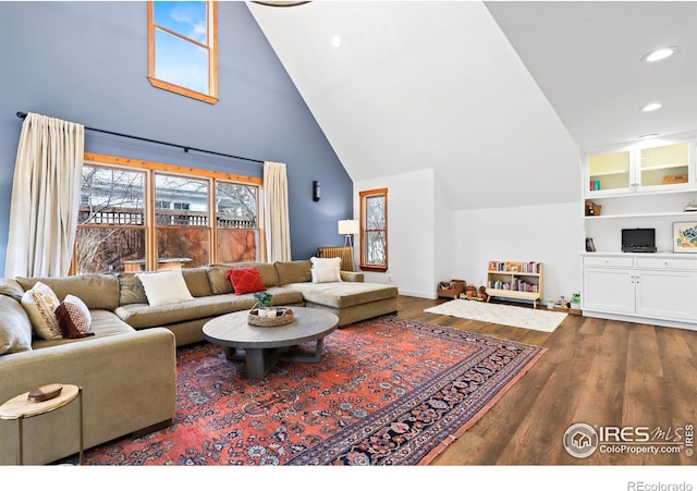 living room with high vaulted ceiling, recessed lighting, baseboards, and wood finished floors