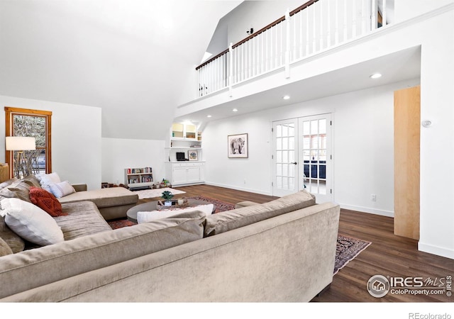 living area featuring recessed lighting, a high ceiling, wood finished floors, baseboards, and french doors