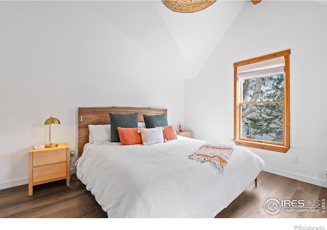 bedroom with dark wood-type flooring, vaulted ceiling, and baseboards