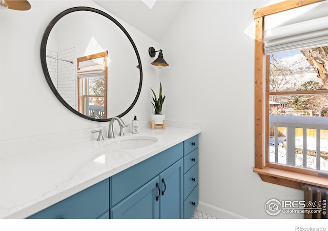 bathroom featuring lofted ceiling, radiator heating unit, vanity, and baseboards