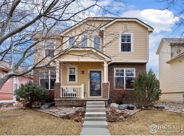 view of front of property with covered porch and brick siding