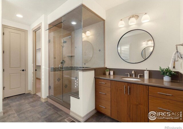 full bathroom with recessed lighting, a shower stall, baseboards, and vanity