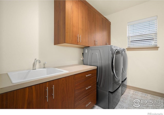 laundry area with washer and clothes dryer, a sink, cabinet space, and baseboards