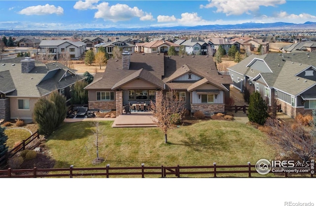 exterior space featuring a residential view, stone siding, a patio, and a front lawn