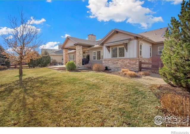 view of front of home featuring fence, a front yard, board and batten siding, a chimney, and a patio area