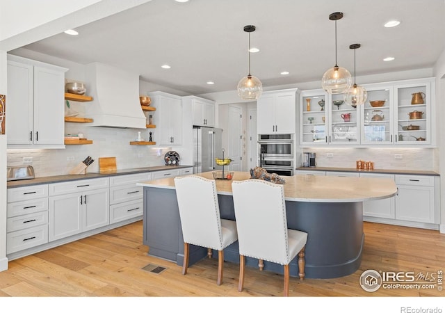 kitchen featuring stainless steel appliances, white cabinetry, and open shelves