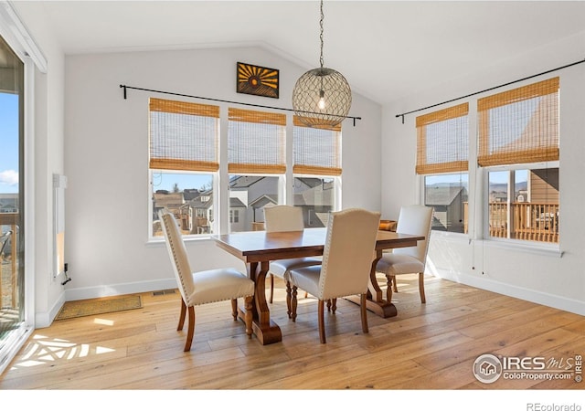 dining area featuring light wood-style floors, lofted ceiling, and plenty of natural light