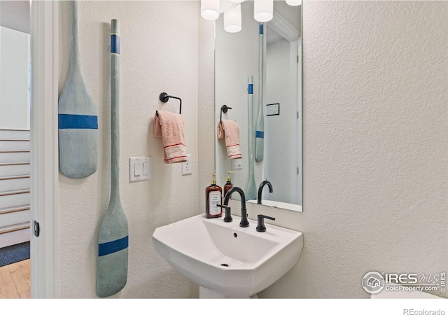 bathroom with a textured wall and a sink