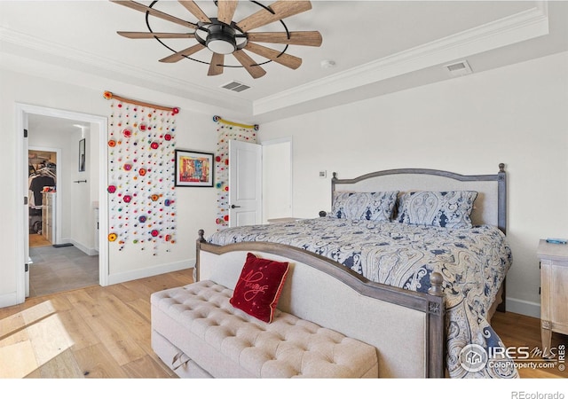 bedroom with light wood-type flooring, visible vents, and crown molding