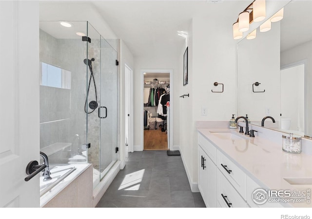 full bathroom with a tub to relax in, a spacious closet, a shower stall, vanity, and tile patterned flooring