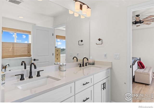 ensuite bathroom with a wealth of natural light, visible vents, and a sink