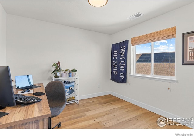 office featuring wood finished floors, visible vents, and baseboards