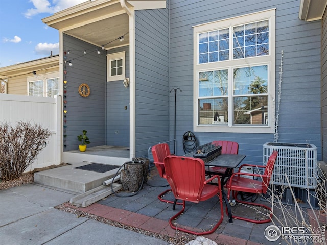 view of patio with outdoor dining area, fence, and central air condition unit