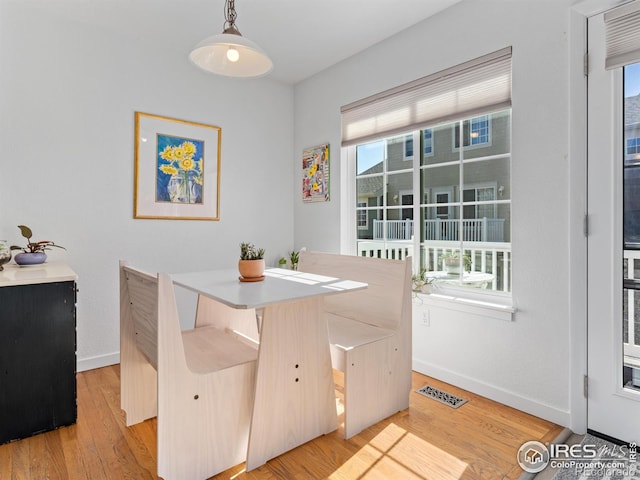 dining area featuring light wood-style floors, baseboards, and visible vents