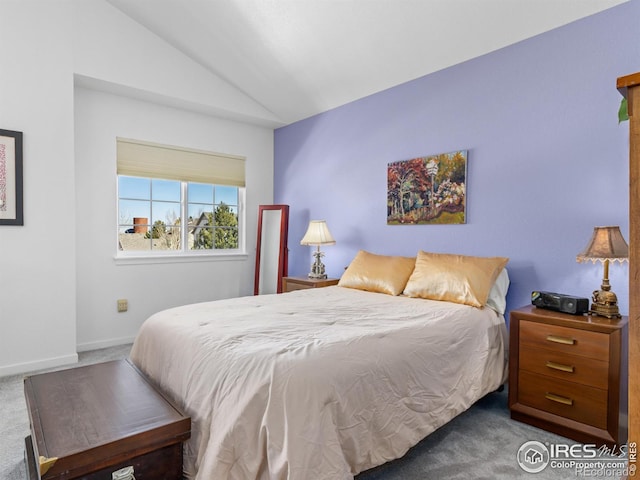 bedroom with vaulted ceiling, carpet flooring, and baseboards