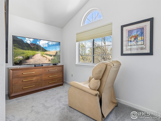 living area with lofted ceiling, light carpet, and plenty of natural light