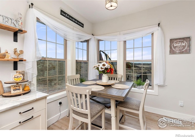 dining area featuring baseboards and light wood-style flooring