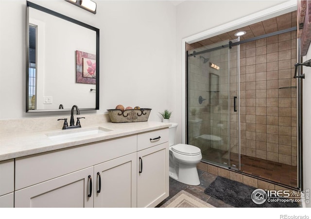 bathroom with vanity, a stall shower, and toilet