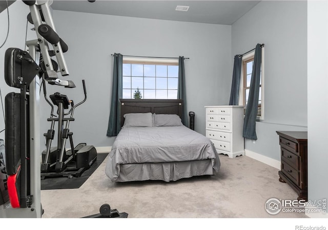 carpeted bedroom featuring baseboards and visible vents