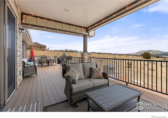 wooden deck featuring an outdoor hangout area, a mountain view, and outdoor dining area