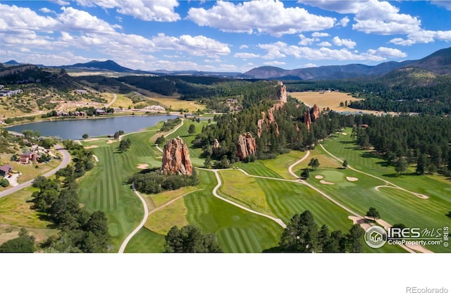drone / aerial view featuring view of golf course and a water and mountain view