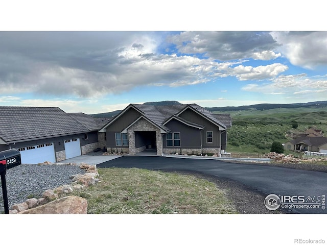 view of front of house with a garage, driveway, and stone siding