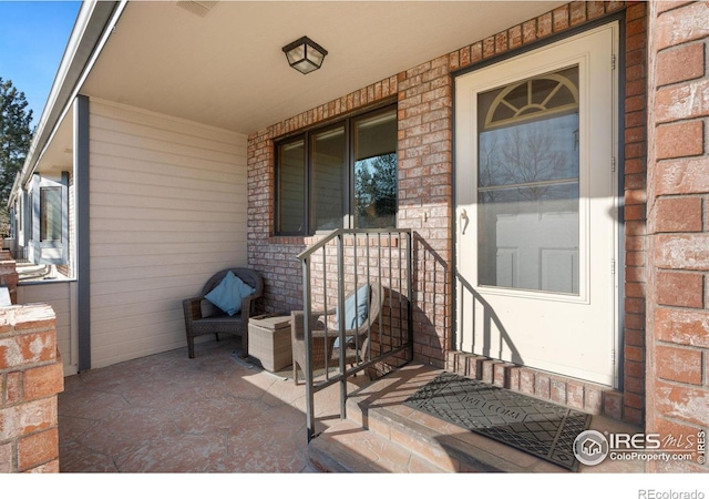 entrance to property featuring brick siding