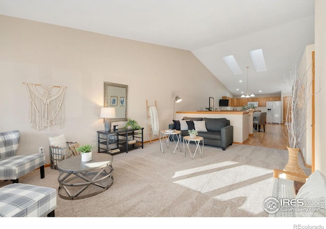 living area featuring a skylight, high vaulted ceiling, and light colored carpet