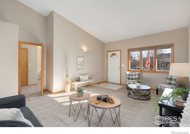 carpeted living room with high vaulted ceiling and baseboards