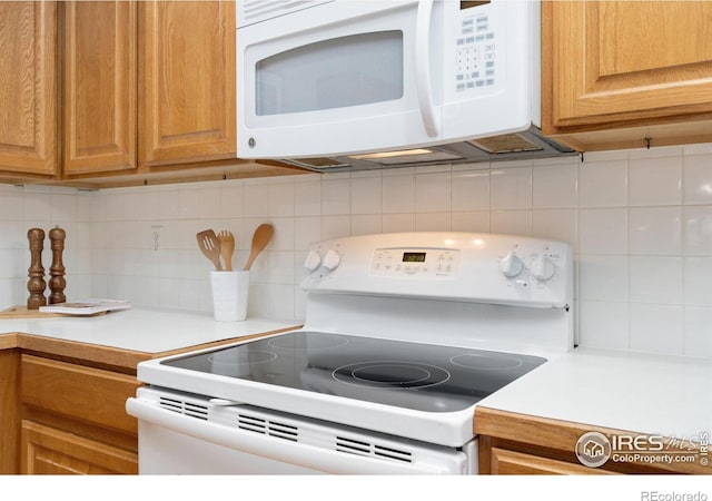 kitchen with light countertops, white appliances, and decorative backsplash