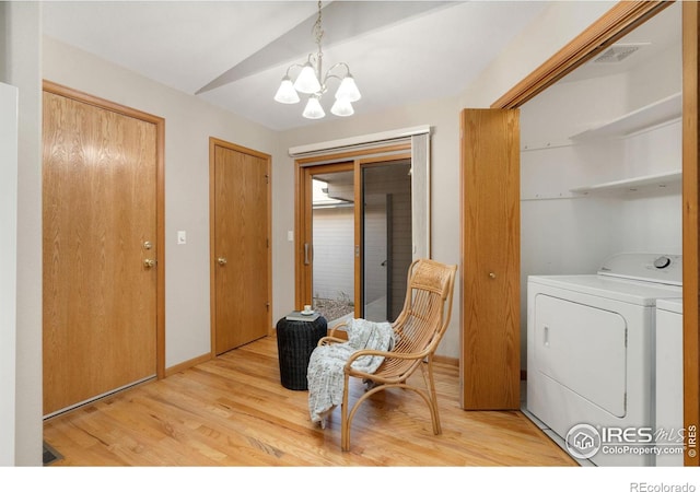 living area featuring visible vents, an inviting chandelier, vaulted ceiling, light wood-style floors, and separate washer and dryer