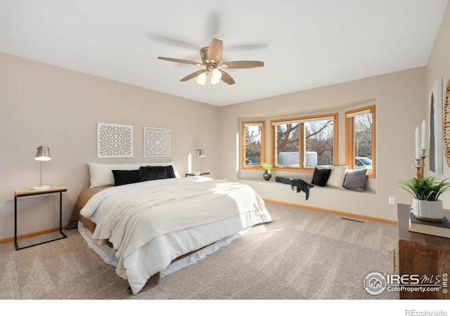 carpeted bedroom featuring visible vents, baseboards, and ceiling fan