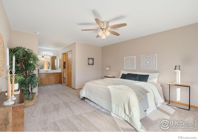 bedroom featuring light carpet, baseboards, a ceiling fan, and ensuite bathroom