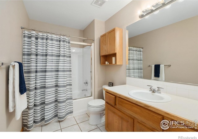 bathroom featuring visible vents, toilet, tile patterned flooring, shower / bath combo with shower curtain, and vanity