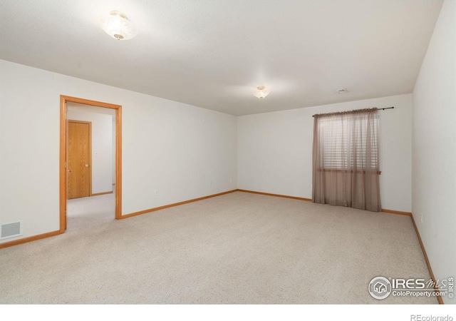 unfurnished room with carpet flooring, visible vents, and baseboards