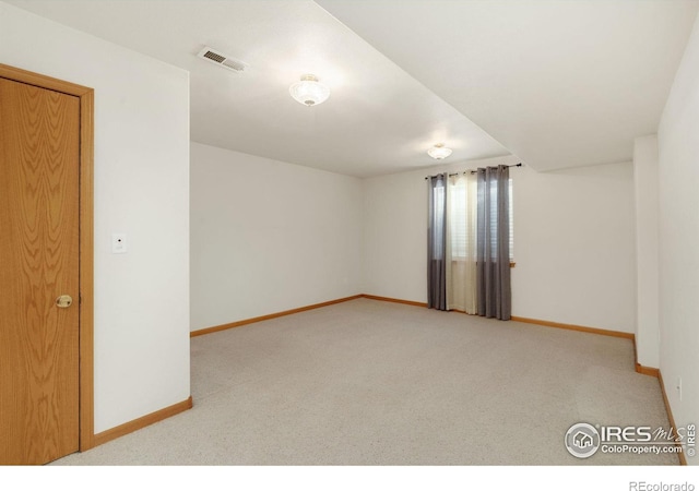 carpeted empty room featuring visible vents and baseboards