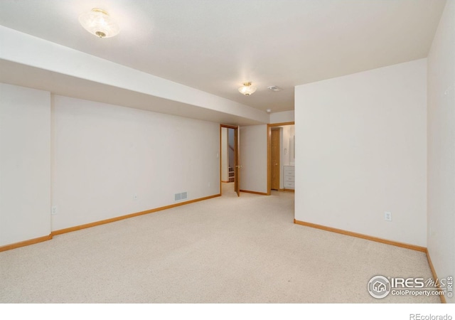 carpeted spare room featuring visible vents and baseboards