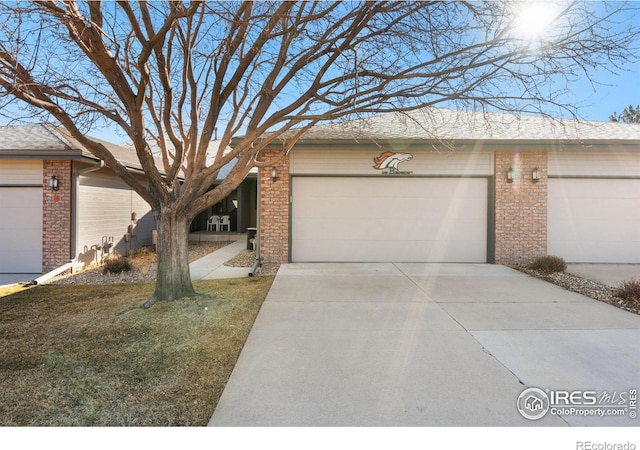 view of front facade with a garage, concrete driveway, and brick siding