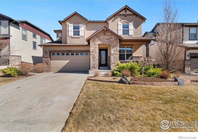 view of front of property with a garage, concrete driveway, stone siding, a front lawn, and stucco siding