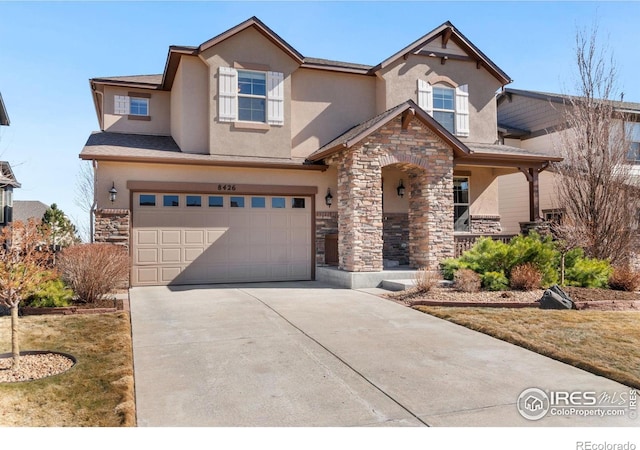 view of front facade featuring stone siding, an attached garage, concrete driveway, and stucco siding