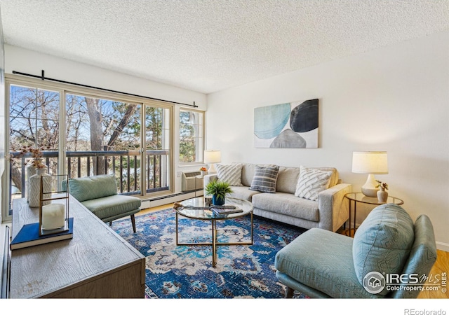 living area with a baseboard heating unit, a textured ceiling, and wood finished floors