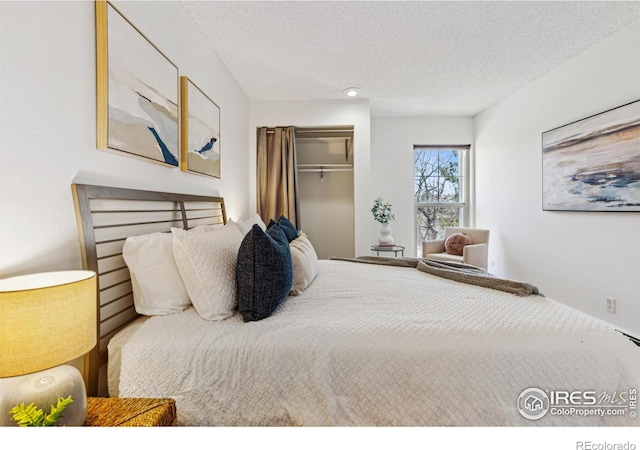 bedroom with a textured ceiling and a closet