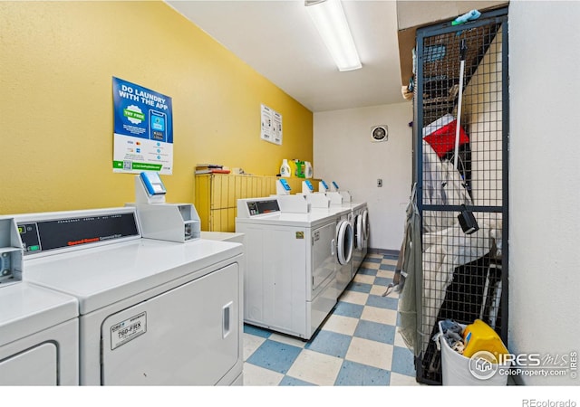 shared laundry area with light floors and independent washer and dryer