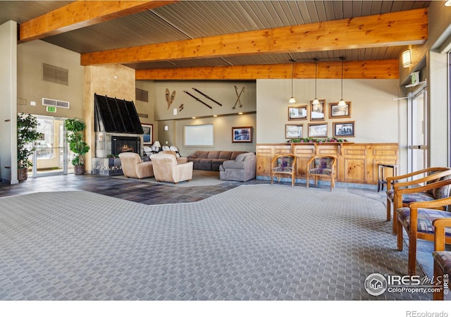 carpeted living area featuring beamed ceiling, a fireplace, and visible vents