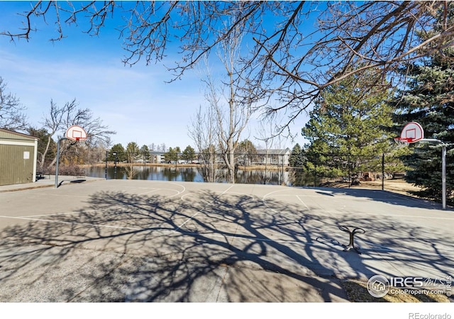 view of yard with community basketball court and a water view